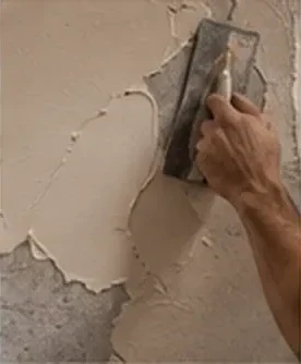 Application d’un enduit à la taloche sur un mur